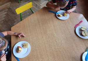 Dzieci oglądają przekrój jabłka.